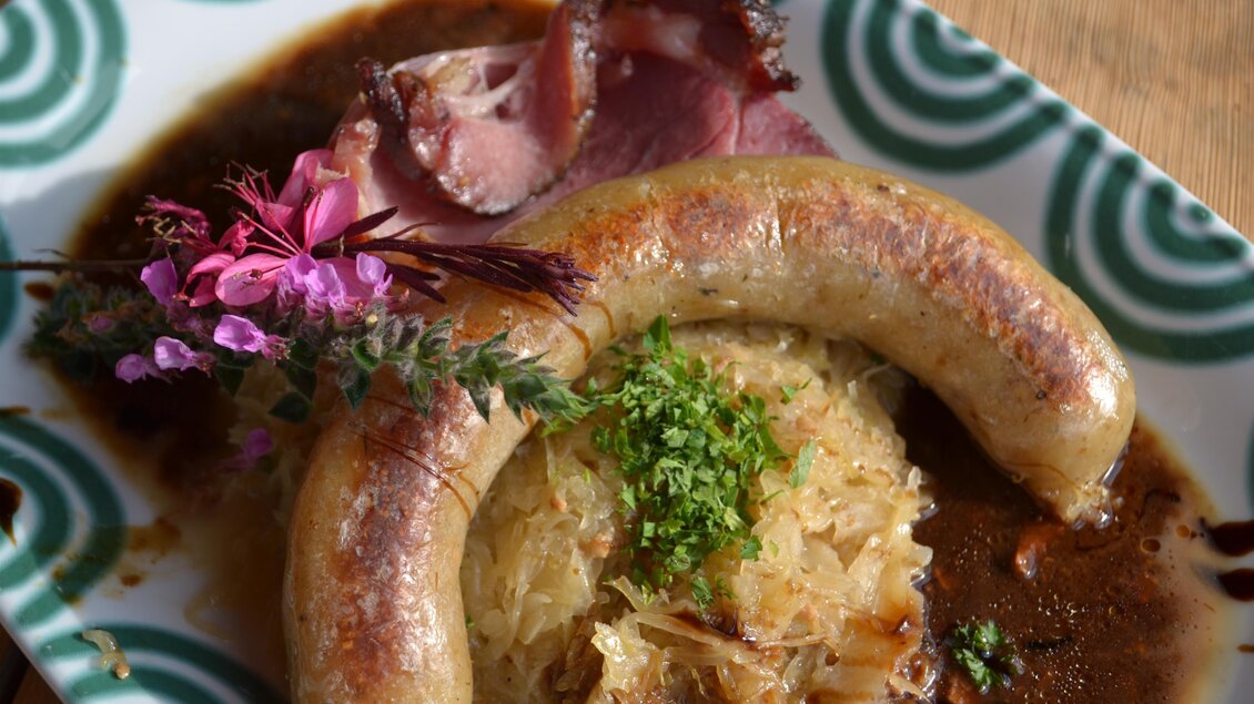 Erdapfelwurst mit Beilagen im Almwirtshaus Holdahütt'n auf der Sommeralm