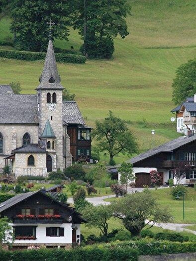 <p><p>Die malerische Landschaft von Grundlsee mit der Pfarrkirche Grundlsee und traditionellen Familienhäusern. Grüne Wiesen umgeben die Szene im Ausseerland.</p></p> | © Rabensteiner