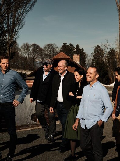 A group of men and women is walking leisurely along a path. They are wearing various casual outfits and seem to be having a pleasant time together. | © Eruptionswinzer