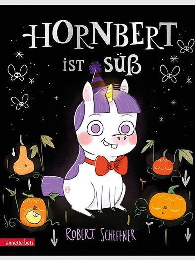 A cute unicorn named Hornbert with a red bow. In the background, there are orange fruits and cheerful motifs. | © Annette Betz