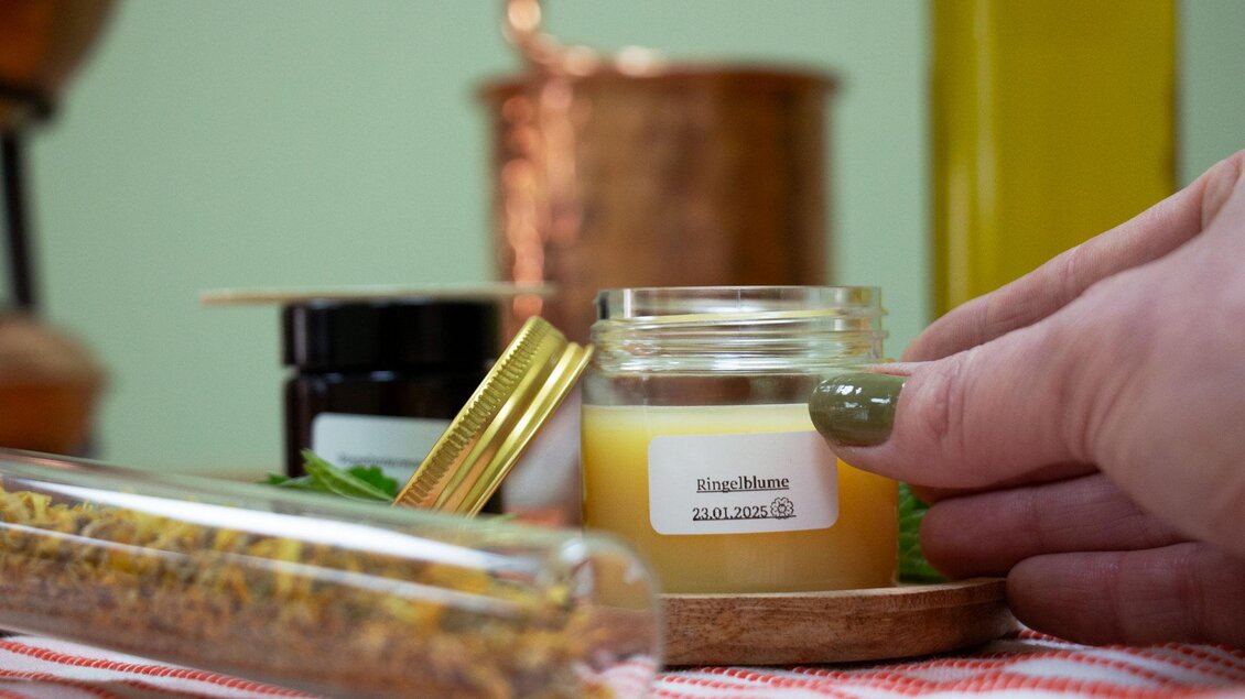 Selbstgerührte Creme im Glas, davor ein Glasröhrchen mit getrockneten Blüten und Kräutern.  | © Evelyne Sauseng-Julia Sauseng