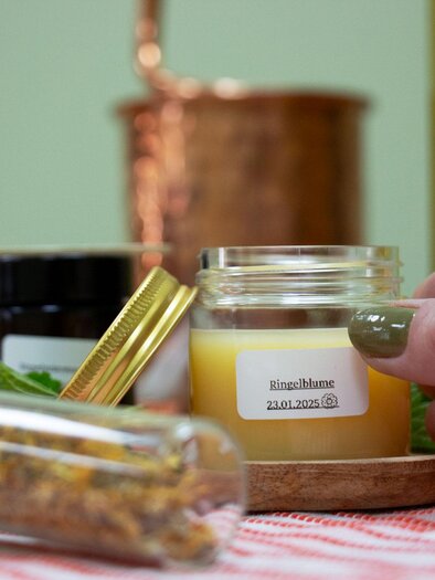 Self-stirred cream in a jar, in front of it a glass tube with dried flowers and herbs. | © Evelyne Sauseng-Julia Sauseng