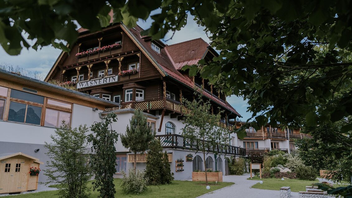 <p>Das Hotel DIE WASNERIN in Bad Aussee überzeugt mit dem rusikalen Erscheinungsbild. Im Vordergrund sind die Blätter eines Baums zu sehen. </p> | © Blattwerk.DasBiotop (c) Wasnerin
