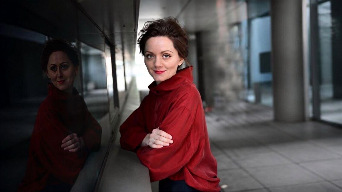 <p><p><p><p>Das Portrait der Autorin Tamara Stajner mit verschränkten Händen und einem roten Pullover.</p></p> | © Die Wasnerin