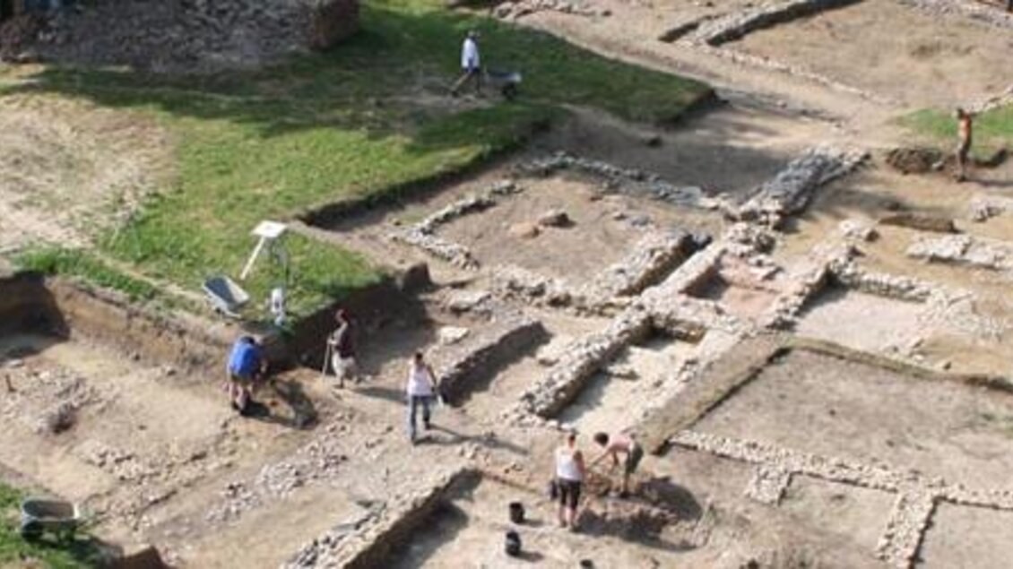 Eine archäologische Ausgrabungsstätte mit sichtbaren Fundamenten und Gruben. Arbeiter sind unterwegs, um historische Überreste zu entdecken. | © Oststeiermark Tourismus