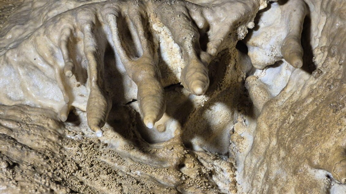 Eine Untertageformation mit Stalaktiten und Stalagmiten aus speziellem Gestein. Die Textur ist rau und fleckig, was die natürliche Schönheit der Höhle zeigt. | © Andrea Stelzer