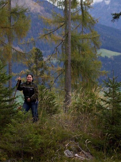 Frau Sabine Jungwirth, Revierleiterin der Österreichischen Bundesforste, steht zwischen den Bäumen in einem Waldgebiet. | © T. Kranabitl.