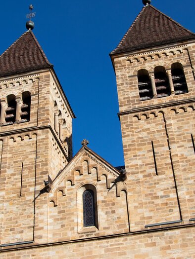 Eine alte Kirche mit zwei Türmen und einer klaren blauen Himmel. Die Fassade besteht aus hellem Stein. | © Isabella Painhapp