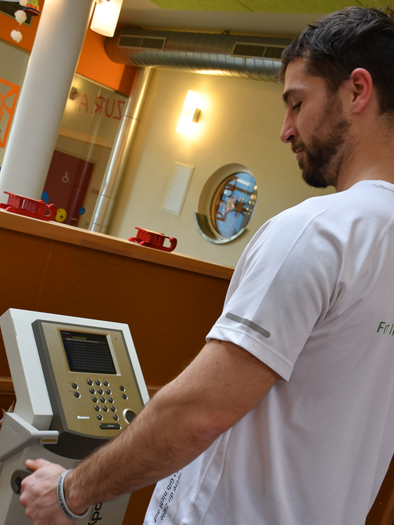 Ein Mann benutzt ein Fitnessgerät in einem modernen Trainingsstudio. Er trägt ein sportliches T-Shirt und konzentriert sich auf die Anzeige. | © H2O-Hoteltherme GmbH/FIT