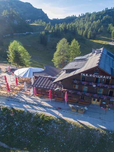 <p>A cozy mountain guesthouse Hollhaus surrounded by green mountain meadows and mountains. In the background, the Tauplitzalm and a clear blue sky can be seen.</p> | © Berggasthof Hollhaus