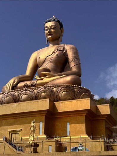 <p>Eine riesige Buddha Statue in Gold. Im Hintergrund sind beeindruckende Felsformationen und blauer Himmel zu sehen.</p> | © Helmut Pichler, www.gosauer.at