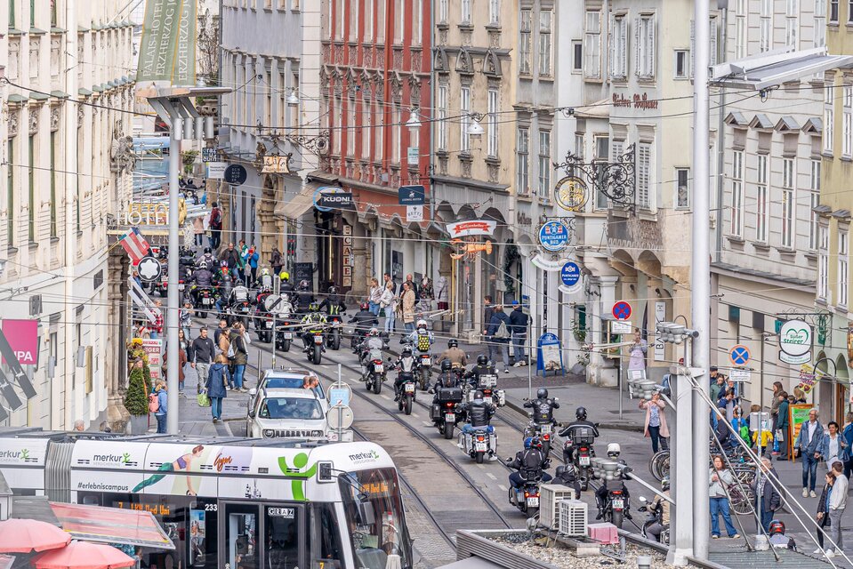 Motorradkorso bei Benefizfahrt am Grazer Hauptplatz, Menschen entlang der Straße und Straßenbahn im Stadtzentrum. | © Fellows Ride