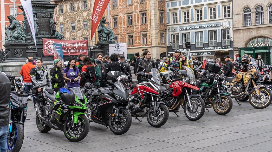 Motorräder und Teilnehmende am Hauptplatz Graz vor Benefizfahrt, historische Fassaden und Erzherzog-Johann-Brunnen im Hintergrund. | © Fellows Ride
