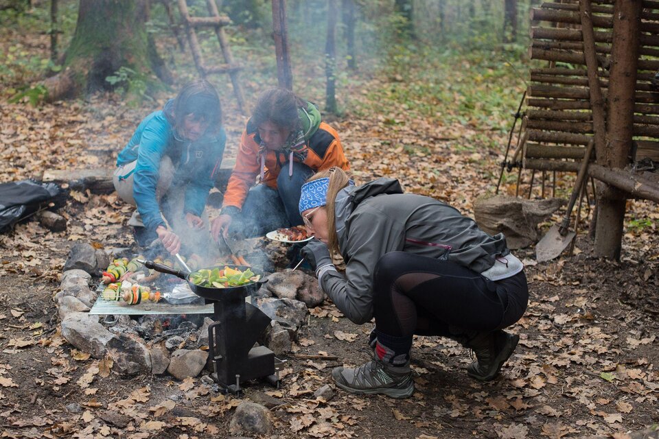 Drei Erwachsene kochen über Lagerfeuer im Wald bei der Hirzmannsperre in Edelschrott, mit Grill und Pfanne. | © Julia C. Pirkenau