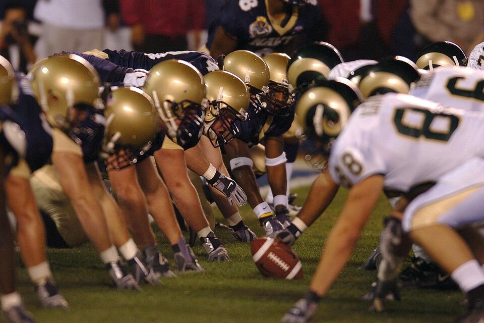 Zwei American-Football-Teams stehen sich auf dem Spielfeld gegenüber. Der Ball liegt in der Mitte, bereit für den nächsten Spielzug. | © Pixbay