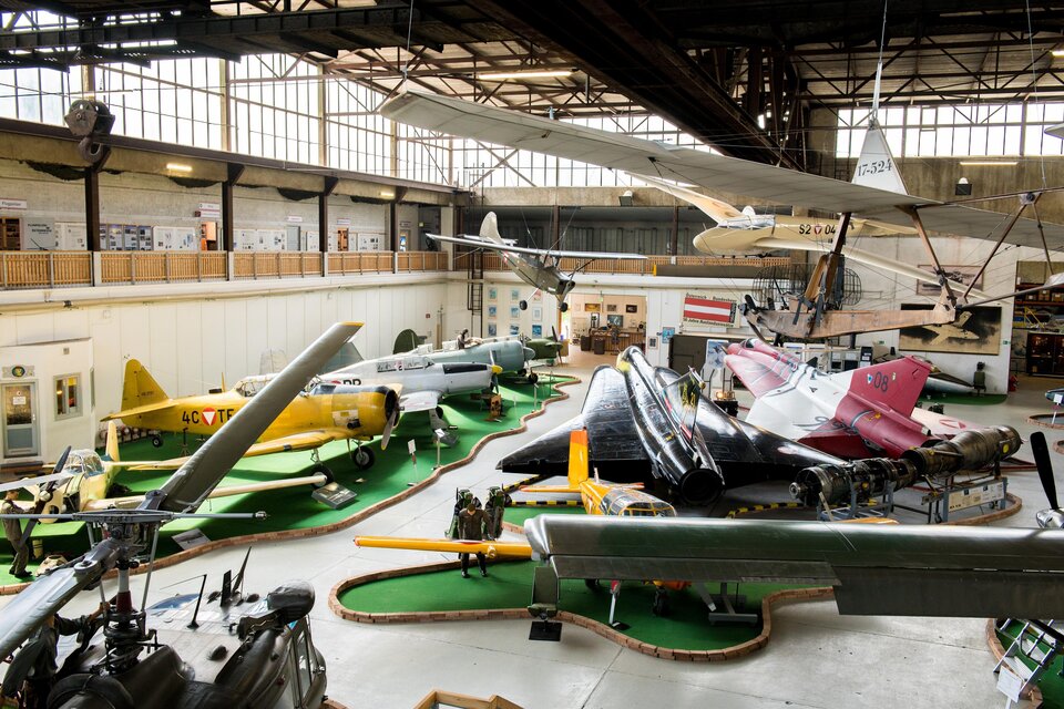 Eine Vielzahl von Flugzeugen ist in einer großen Halle ausgestellt. Die Sammlung umfasst verschiedene Modelle in unterschiedlichen Farben und Formen. | © AnitaFössl