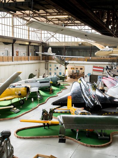 A variety of aircraft is exhibited in a large hall. The collection includes different models in various colors and shapes. | © AnitaFössl
