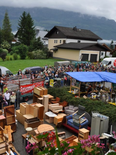 A large flea market with many furniture and household items is set up outdoors. Many people are gathered in a long line, watching the stalls. | © Freiwillige Feuerwehr Bad Mitterndorf