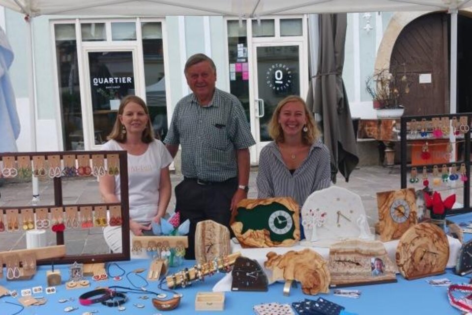 Ein Marktstand mit drei Personen, die Handwerkskunst und Schmuck präsentieren. Es gibt viele verschiedene Gegenstände auf dem Tisch, die zum Kauf angeboten werden. | © Oststeiermark Tourismus