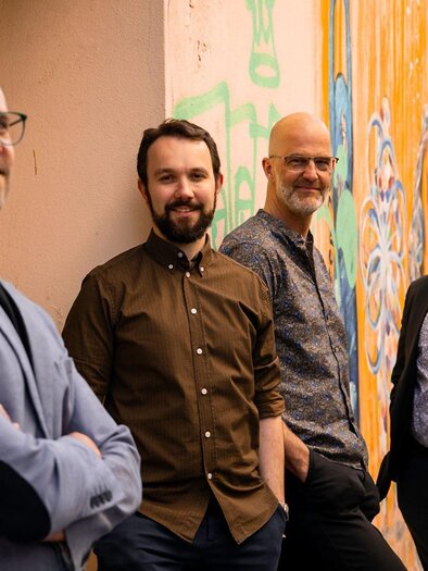 Die vier Musiker der Band „Following Footsteps“ präsentieren sich in entspannter Atmosphäre vor einer farbenfrohen Graffitiwand. Mit ihrem modernen und lässigen Auftreten vermittelt die Gruppe musikalische Vielfalt, Kreativität und die Freude an gemeinsamer Musik. Zu hören im Kulturhauskeller in Straden.

 | © Viola Lenz
