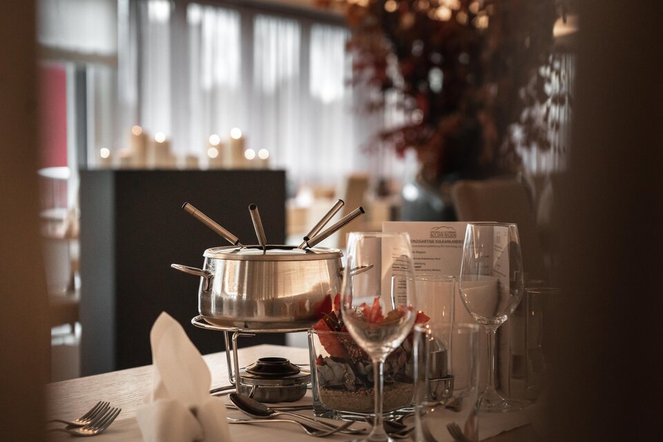 Stilvoll gedeckter Tisch mit Fondue im Vulkanlandhotel Legenstein. Warmes Licht, Kerzenschein und herbstliche Dekoration schaffen eine gemütliche Atmosphäre für genussvolle Stunden. | © Vulkanlandhotel Legenstein