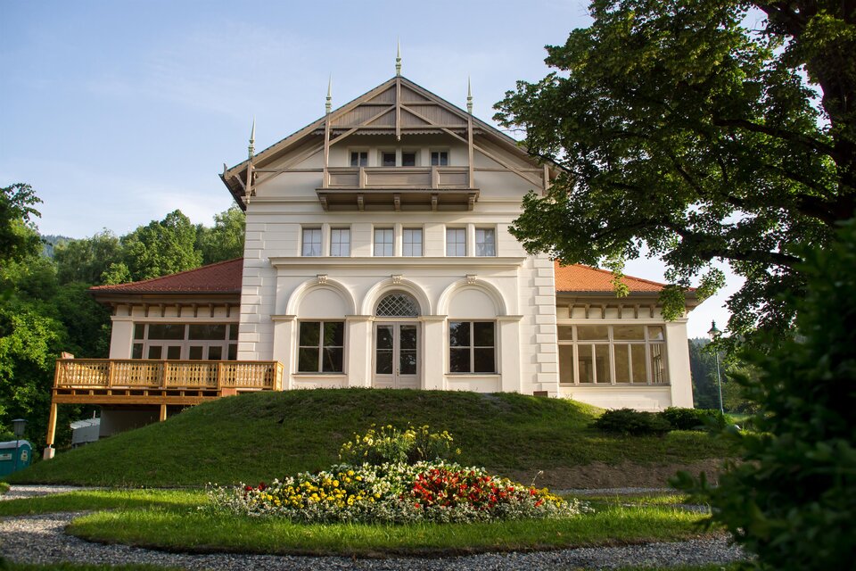 Ein stilvolles Gebäude mit einem großen Garten und bunten Blumen. Die Architektur ist attraktiv und harmoniert mit der Umgebung. | © Ursula Schwarzl
