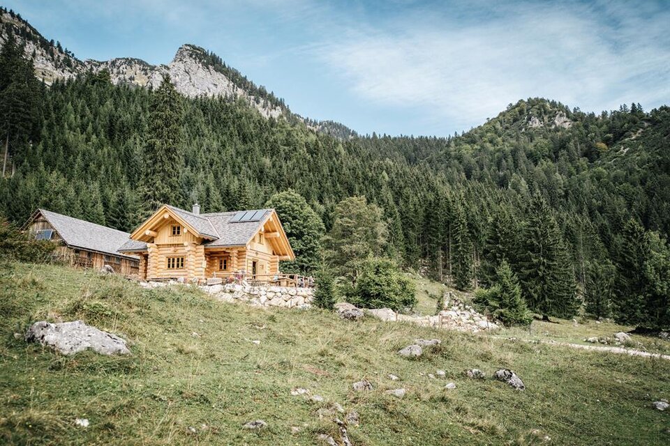 Ein charmantes Holzhaus inmitten von Bergen und Wäldern. Die Szene strahlt Ruhe und Naturverbundenheit aus. | © Stefan Leitner