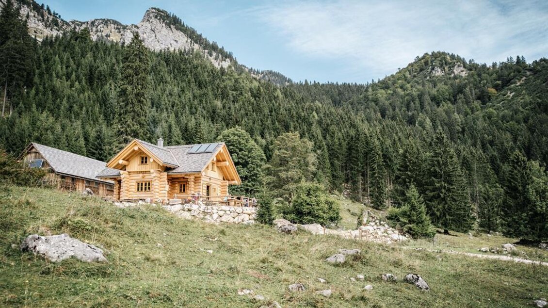 Ein charmantes Holzhaus inmitten von Bergen und Wäldern. Die Szene strahlt Ruhe und Naturverbundenheit aus. | © Stefan Leitner