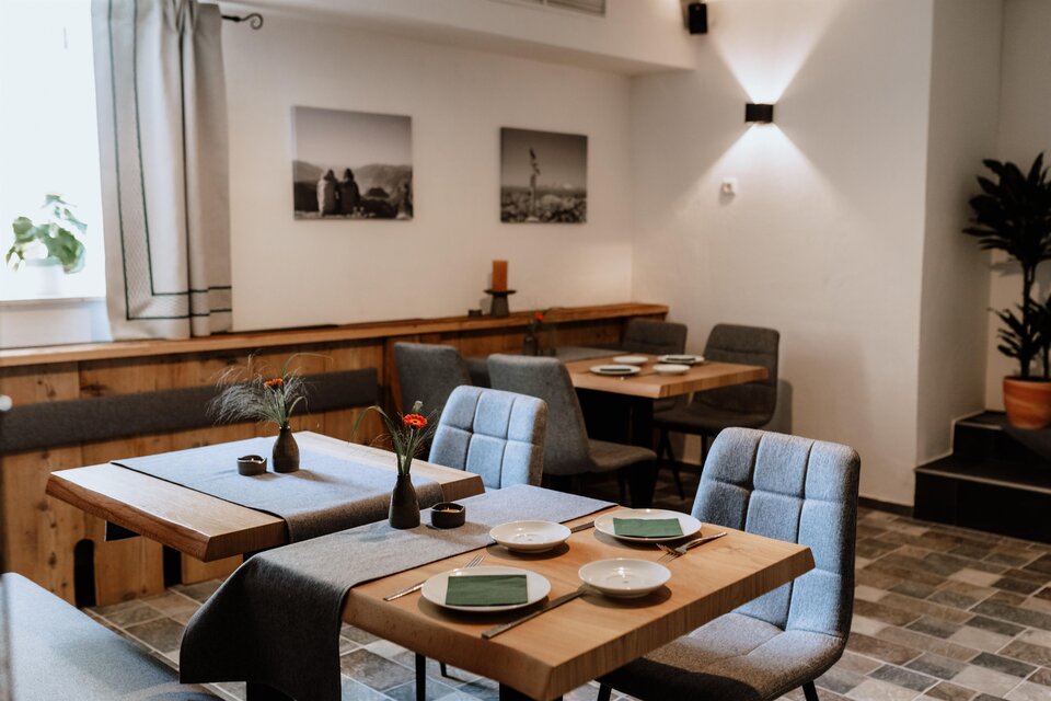 Das Restaurant vom Schutzhaus am hohen Camper mit Holztischen und bequemen Stühlen. An der Wand hängen Bilder vom Ausseerland, und es gibt Pflanzen zur Dekoration.</p> | © Das Schutzhaus am hohen Camper