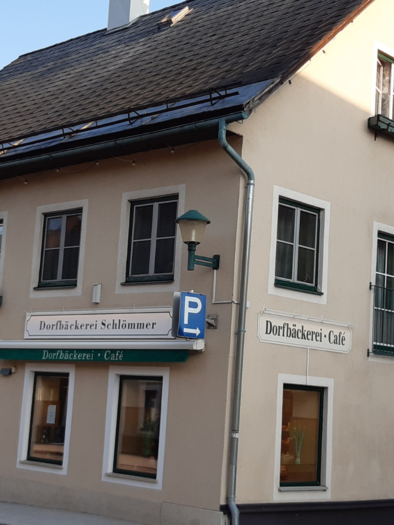 Ein gemütliches Café mit einer hellen Fassade und Fenstern. Vor dem Gebäude befinden sich Blumen und ein Parkplatz. | © TVB Ausseerland Salzkammergut/ Daniela Casari
