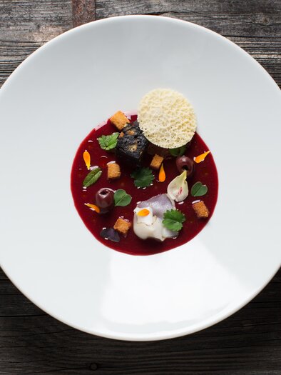 An artfully arranged dish on a white plate. It consists of a red sauce, various pieces of vegetables, and a crispy garnish. | © Der WILDe EDER