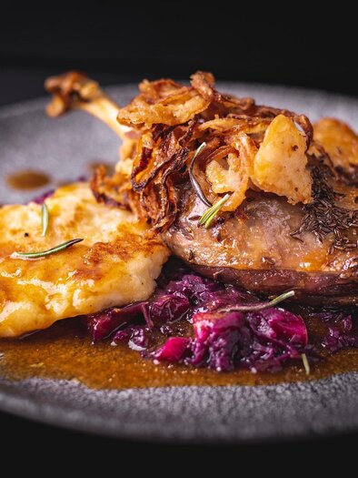 Ein Gericht mit zartem Fleisch, knusprigen Zwiebeln und einer leckeren Sauce. Dazu gibt es Kartoffelpüree und Rotkohl. | © Winterleitenhütte