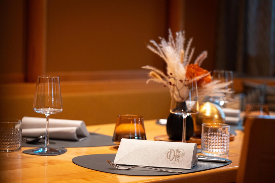 Ein elegant gedeckter Tisch mit Gläsern und einem schönen Blumenarrangement. Die Atmosphäre ist warm und einladend. | © Rene Strasser