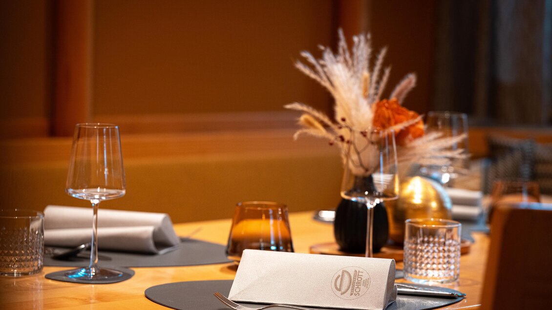 Ein elegant gedeckter Tisch mit Gläsern und einem schönen Blumenarrangement. Die Atmosphäre ist warm und einladend. | © Rene Strasser