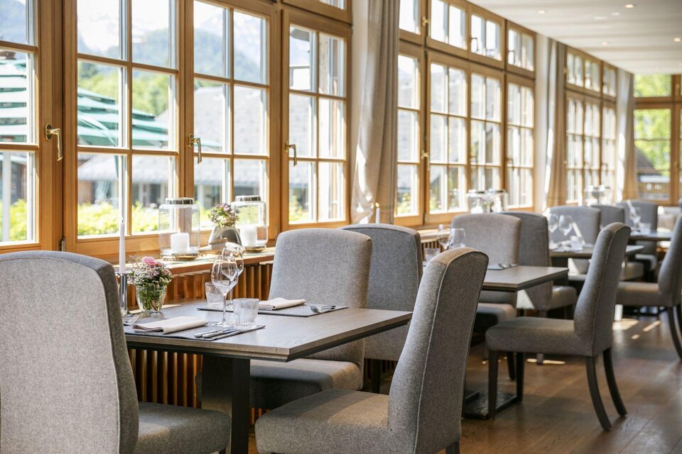 <p>Das moderne Restaurant im Seehotel Grundlsee mit großen Fenstern und einen direkten Blick auf den Grundlsee. Die Tische sind elegant gedeckt und laden zum Verweilen ein.</p> | © Seehotel Grundlsee
