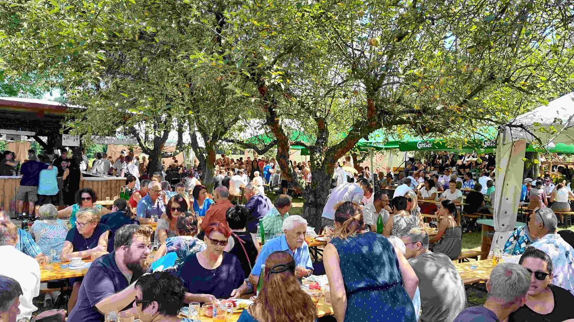 <p>Großes Gartenfest in Edersgraben bei Feldbach mit zahlreichen Besucherinnen und Besuchern unter schattigen Bäumen, gemütlichen Festbänken und regionaler Kulinarik – gelebte Gemeinschaft, Vereinskultur und gesellige Sommerstimmung in der Erlebnisregion Thermen- & Vulkanland.</p> | © FF Edersgraben