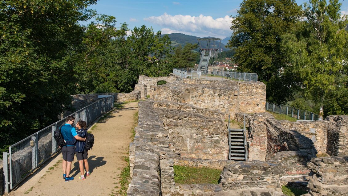 Eine wunderschöne Ruine mit einem schmalen Weg, umgeben von Bäumen. Zwei Personen erkunden die historischen Überreste. | © TVB Erzberg-Leoben