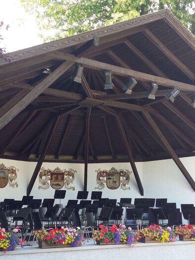 A spacious stage with a high wooden roof. Surrounded by flowers and cornices, it is ready for an event. | © Petra Kirchschlager