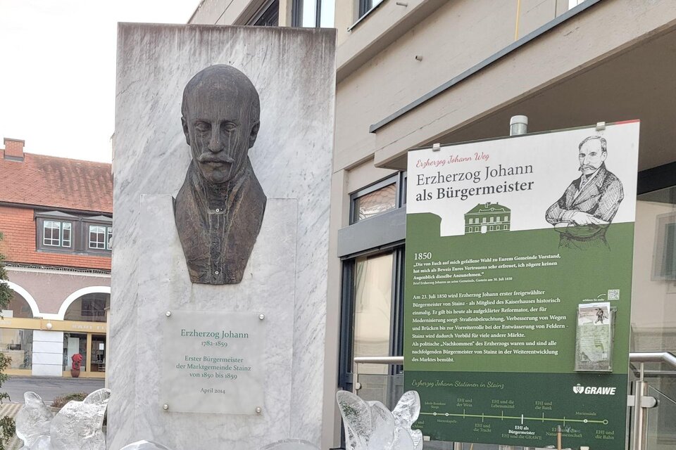Eine Statue von Erbherzog Johann steht auf einem Podest. Daneben befindet sich ein Informationsschild über seine Rolle als Bürgermeister. | © TV Südsteiermark - Irene Löschnig