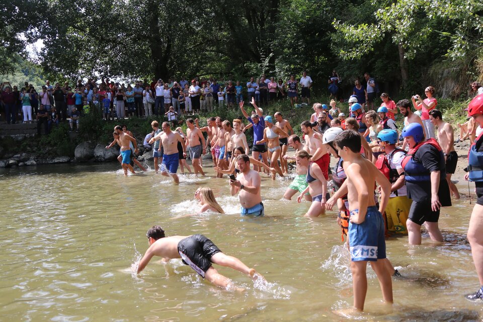 Eine Gruppe von Kindern und Jugendlichen steht im Wasser und spielt. Zuschauer beobachten das Geschehen am Ufer. | © GlaMur