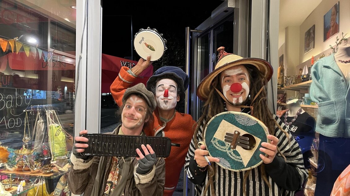 Drei Clowns stehen in einer Tür und halten Musikinstrumente. Sie haben bunte Kleidung und rote Nasen, was eine fröhliche Atmosphäre schafft. | © Tourismusverband Oststeiermark