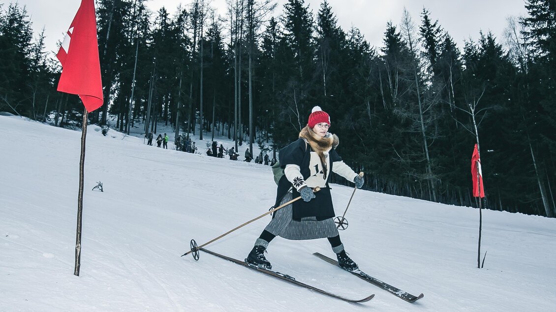 Eine Skifahrerin bewegt sich auf einer schneebedeckten Piste. Im Hintergrund sind Bäume und andere Skifahrer zu sehen. | © Oliver Königshofer