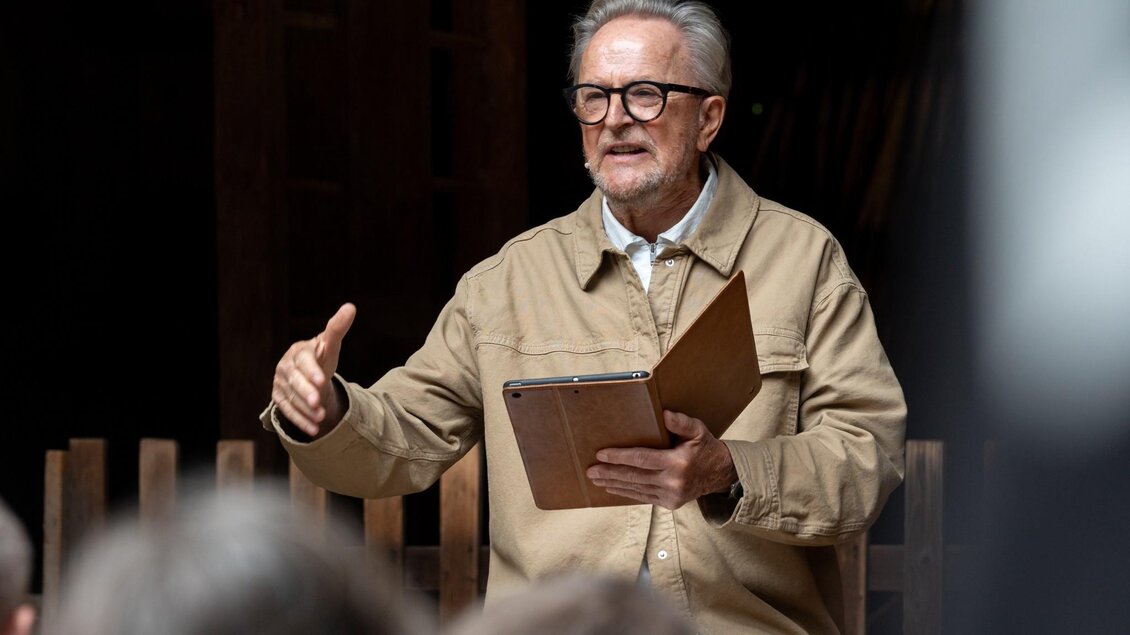 Folke Tegetthoff erzählt beim Storytelling Festival Schlossträume vor Publikum und hält ein Tablet in der Hand. | © David Dunst