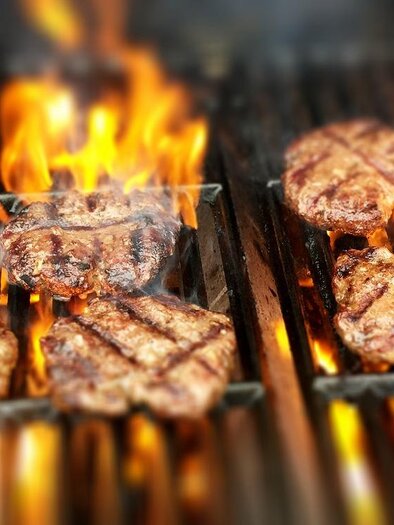 Finom burgerpattikat grillezünk nyílt tűz felett. A lángok tökéletes grillezési színt és füstös aromát biztosítanak.