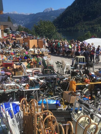 A flea market with many different items and a long line of people in the background. The surroundings are surrounded by mountains and a beautiful landscape. | © Freiwillige Feuerwehr Grundlsee