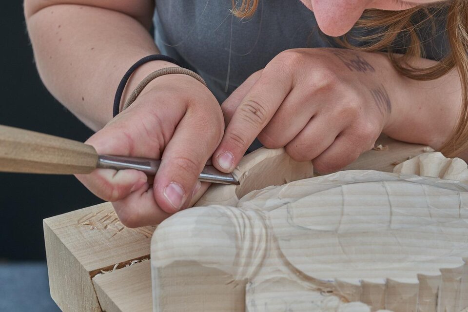 Eine Person schnitzt mit einem Werkzeug in ein Stück Holz. Die Hände sind konzentriert bei der Arbeit an der Holzfigur. | © RoyBuri | Pixabay.com