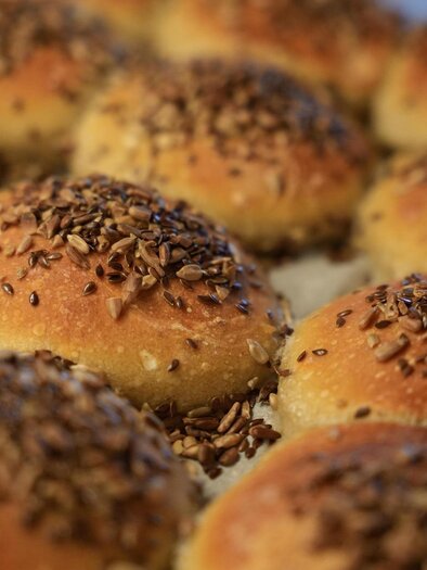 Frisch gebackene Brötchen mit einer goldbraunen Kruste und Leinsamen obendrauf. Die Brötchen liegen auf einem Backblech. | © Pixabay