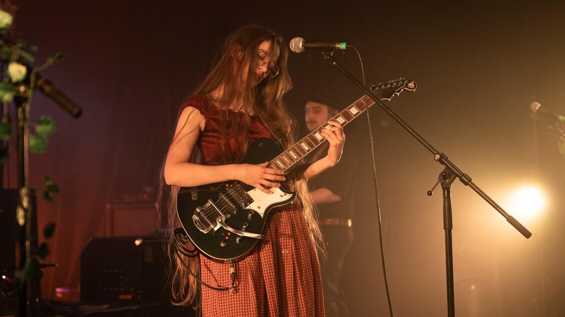 Musikerin mit langen braunen Haaren mit Gitarre | © Michael Fasching