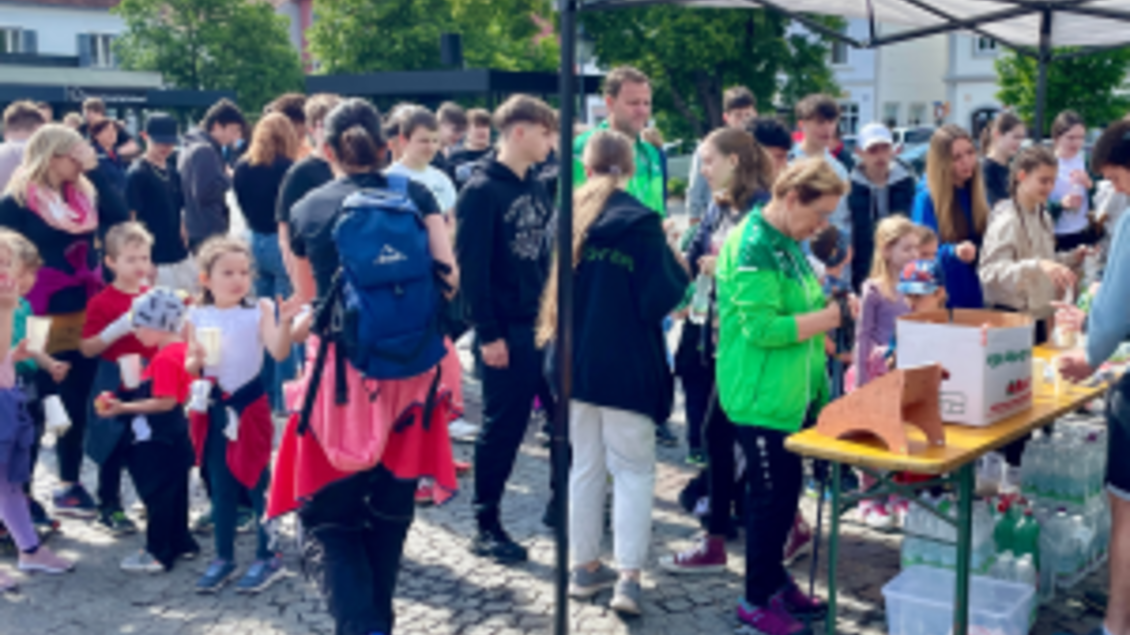Eine große Menschenmenge versammelt sich auf einem Platz. Einige stehen an einem Stand, während andere miteinander reden und die Atmosphäre genießen. | © Lebenshilfe Fürstenfeld