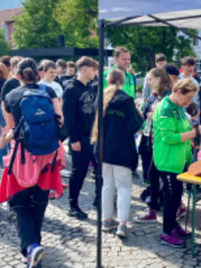 Eine große Menschenmenge versammelt sich auf einem Platz. Einige stehen an einem Stand, während andere miteinander reden und die Atmosphäre genießen. | © Lebenshilfe Fürstenfeld